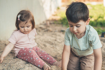 Sister and brother playing dirty soil on spring day in the garden. People lifestyle concept. Happiness concept. Family lifestyle concept. Family activity