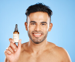 Indian man, serum and skincare with smile for natural beauty, organic facial and wellness with blue...