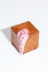 Puff pastry cube shaped croissant with creamy berry sauce and candied strawberry crumble
