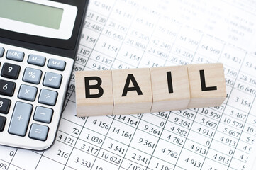 four wooden cubes with word BAIL on white working board.