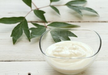 Obraz na płótnie Canvas Yogurt in a clear glass bowl. Fresh organic yogurt on the white wooden table.