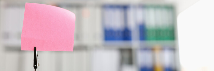 Pink blank note sticker on desk in office closeup