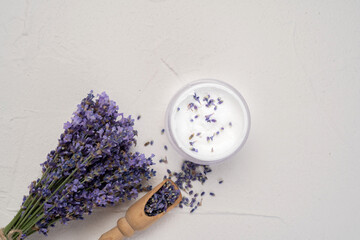 Bunch of fresh lavender flowers and moisturizing face cream on white background. Top view, flat lay...