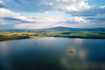 Fototapeta na wymiar Aerial top view of beautiful landscape with large lake against mountains shapes at summer day. Mietkow lake near Wroclaw, Poland