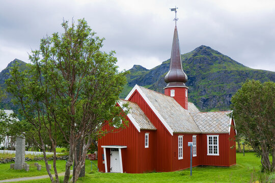 Red wooden church built in a cruciform style in Flakstad, Lofoten, Norway