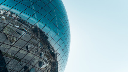 Large glass blue sphere against the sky, exterior. Modern futuristic architecture ball with...