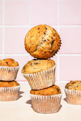 Close-up of chocolate and banana muffins in stack, colorful background, hard light