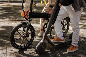 Naklejka premium People with electric scooter and bicycle outside.