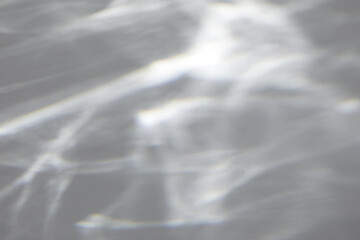 Blurred water texture overlay effect for photo and mockups. Organic drop diagonal shadow and light caustic effect on a white wall. Shadows for natural light effects