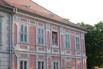 Beautiful salmon colored facade and sculpture of an old house in the Balkans