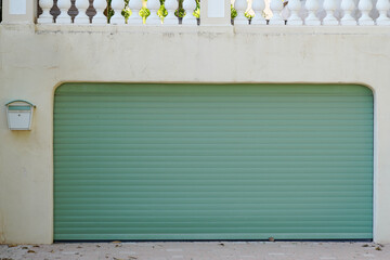 metallic green plastic curtain of closed roller garage gate home access