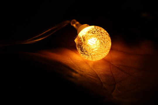 Light Bulb On The Hand  Outdoor Party String Lights Hanging In Backyard On Hand Bokeh Background