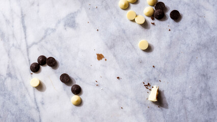 white and dark chocolate chips on dirty marble background
