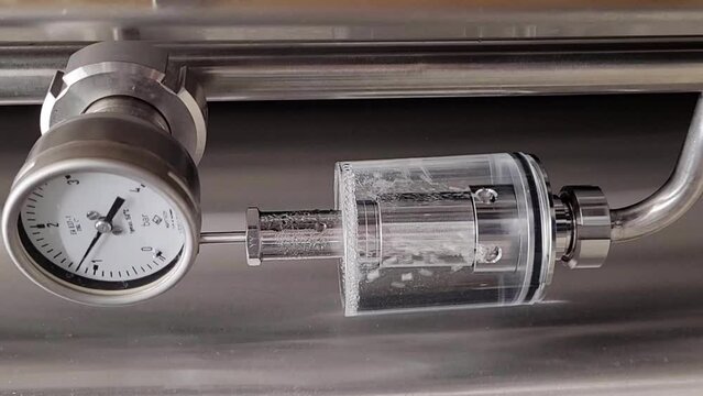 Craft beer brewing equipment in the brewery. Modern beer plant. Metal tanks, process of alcoholic drink production. 