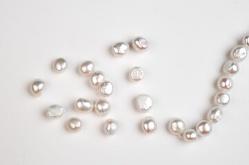 Baroque pearls strand. Natural freshwater pearl beads on white background. Top view