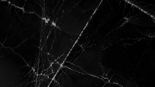 Black paper dusty wrinkled texture with abstract crumpled pattern. Monochrome cardboard wrinkles. Macro. Rotation. Top view