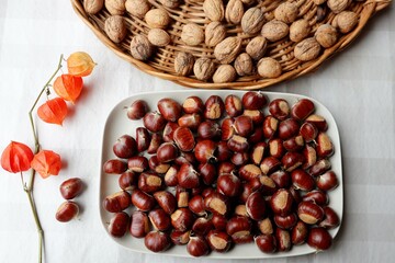 Autumn still life: ripe walnuts, chestnuts and bright physalis.