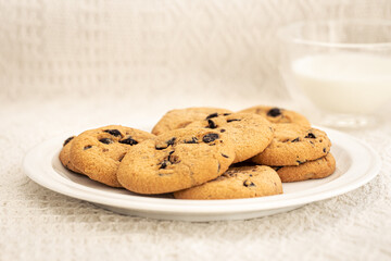 Cookies with chocolate chips close-up and glass of milk.