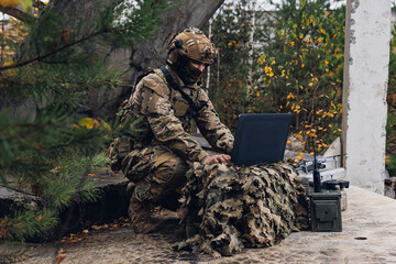 Soldier engineer use laptop for transmits aerial photo and data from drone to headquarters military. Concept smart war robots