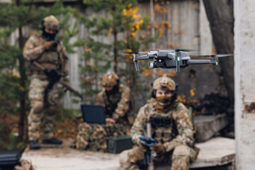 Military soldier controls drone for reconnaissance operation of enemy positions. Concept using...