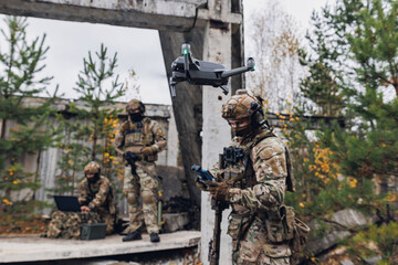 Modern army soldiers using aerial drone for artillery guidance and scouting view enemy positions in military operation