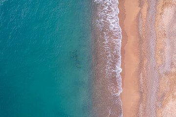 Turquoise water with wave with sand beach background from aerial top view. Concept summer sunny travel image