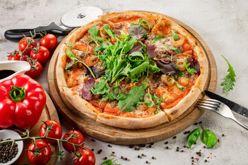 Fresh pizza with meat and vegetables on the concrete background