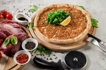 Tasty pizza with a veal meat and herbs on the concrete background