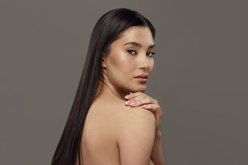 Naklejka premium Luxurious young woman with naked back, long dark hair.