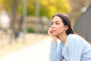 Relaxed woman contemplating sitting in a park