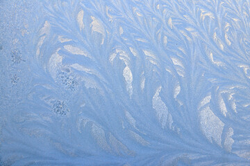 Frost pattern on a frozen window at winter. Natural background, texture