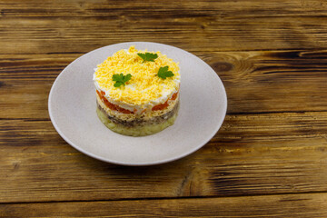 Traditional russian salad Mimosa on wooden table
