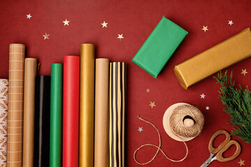 Christmas background with gift boxes and rolls of colored kraft wrapping paper. Xmas celebration,...