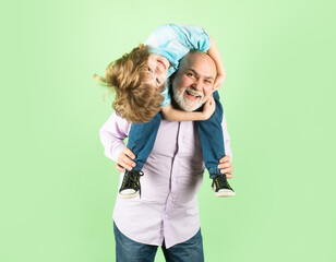 Old grandfather and young child grandson piggyback ride with funny face isolated. Elderly old...