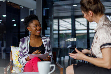Smiling businesswoman listening to colleague in office