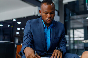 Portrait of formal African businessman leading business meeting in corporate office