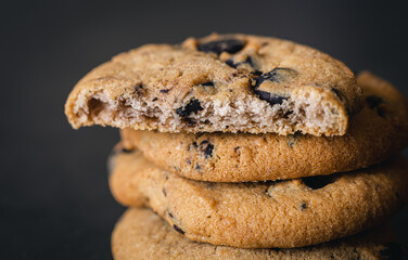 Chocolate chip cookies close up on a black background.