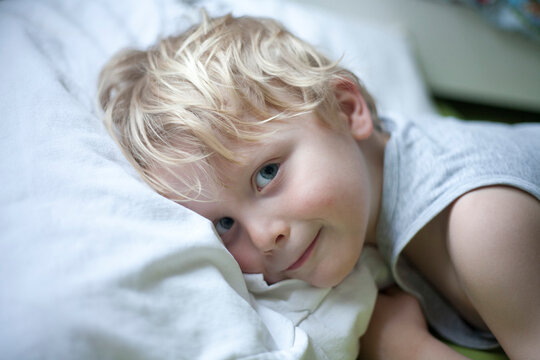Portrait of little boy lying in bed