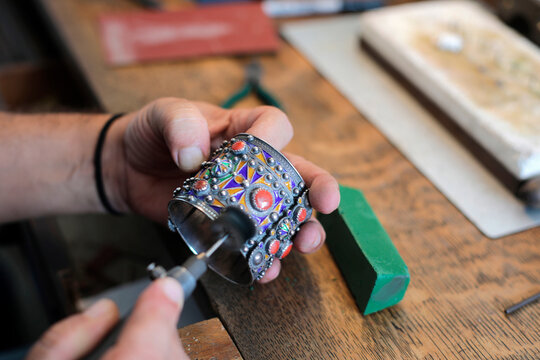 Hands of jeweller polishing bangle in workshop