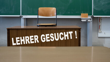 LEHRERMANGEL an deutschen Schulen - Leeres Klassenzimmer mit Schultafel, Lehrerpult mit hochgestelltem Stuhl und der Aufschrift: LEHRER GESUCHT ! - obrazy, fototapety, plakaty