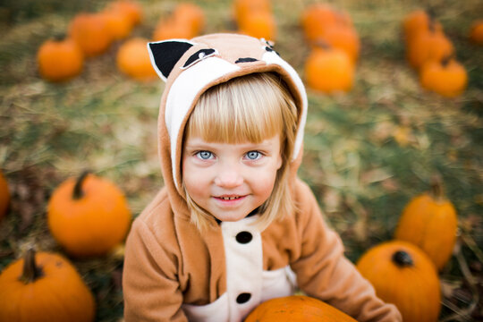 Smiling girl wearing fox costume at pumpkin farm