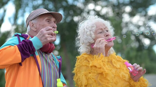 Happy successful old couple celebrating a life together outdoor. Funny senior woman and man wearing fashionable cool clothes having fun outside in the city