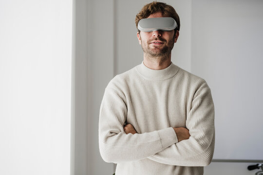 Businessman with arms crossed wearing futuristic goggles