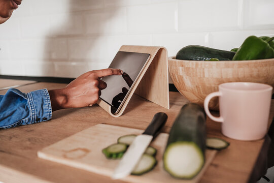 Hands of woman using tablet PC at kitchen counter