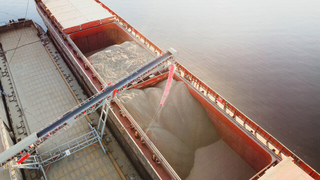 Grain Loading In Hold Of Bulk Carrier Ship With Elevator Crane Closeup. Port Grain Elevator.