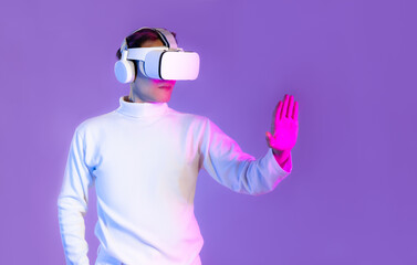 Metaverse, asian man in white t shirt wearing vr goggles headset and headphone hand touching on purple color background.
