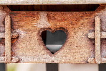 Wooden mailbox with a carved slot in a heart shape with a letter