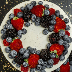 delicious bright cake with fruit on top and filling, the cake is standing on a black table