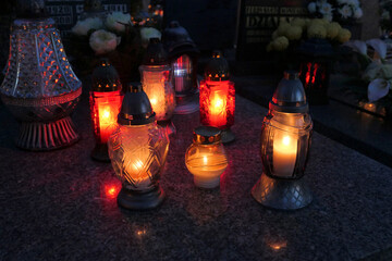 Lighting candles on the grave at night. All the Saints Day holiday on 1 November in Poland