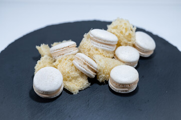 White vanilla macarons, sponge mousse cake, black dish, french dessert